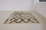 Remi is a vintage Beni Ourain from the middle Atlas mountains, with a rare design featuring tribal symbology. Thick natural wool carpet in black and white pattern.