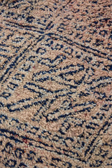 Sylvie is a peach and dark blue geometric patterned vintage Beni Ourain rug with a thick, cozy pile.