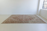 A handmade antique Persian carpet made from wool and featuring a Heriz design with central medallion.