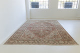 A handwoven antique Persian Heriz rug featuring a classic design with central medallion.