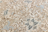 The Portia rug features an intricate all over Heriz design comprised of floral and palmette motifs set against a taupe ground and muted blue toned boarder. A beautiful antique carpet.