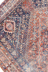 A Qashqai carpet. Sydney features a striking central diamond medallion, a classic motif in Qashqai weaving, framed by a repeating floral, boteh and gul pattern.