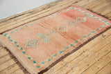A vintage Boujad rug with a peach and sage green color palette, featuring geometric patterns and berber symbology, approximately 40 years old