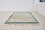 Trudie is an original Swedish röllakan rug handwoven by mid-century textile designer Anna Johanna Angström. Green colour-way featuring floral motifs