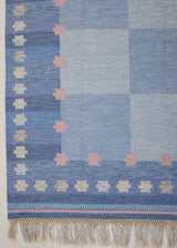 an original Swedish röllakan rug handwoven by mid-century textile designer Anna Johanna Angström. Her colourful kilim features strong lines in a blue and pale blue checkered pattern with accents of pink and cream