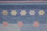 an original Swedish röllakan rug handwoven by mid-century textile designer Anna Johanna Angström. Her colourful kilim features strong lines in a blue and pale blue checkered pattern with accents of pink and cream
