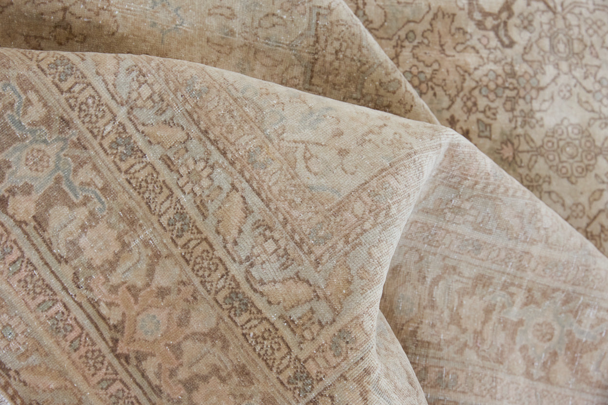 Cecil is a beautiful antique Persian Tabriz rug with a soft and subtle colour palette and in an extra large size. This pretty carpet features highly detailed flowers, palmettes, arabesques and leafy sprays throughout the field and borders, symbolising nature and beauty.
