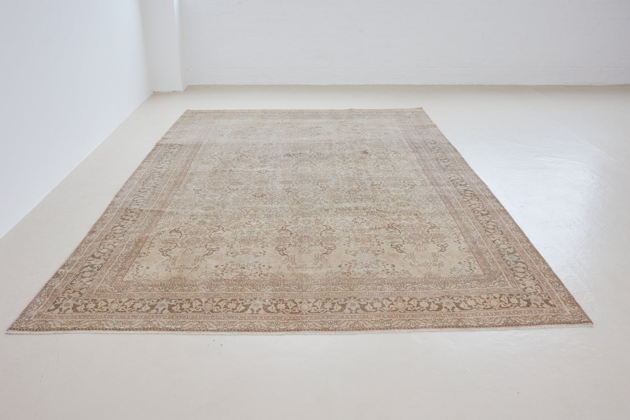 Cecil is a beautiful antique Persian Tabriz rug with a soft and subtle colour palette and in an extra large size. This pretty carpet features highly detailed flowers, palmettes, arabesques and leafy sprays throughout the field and borders, symbolising nature and beauty.