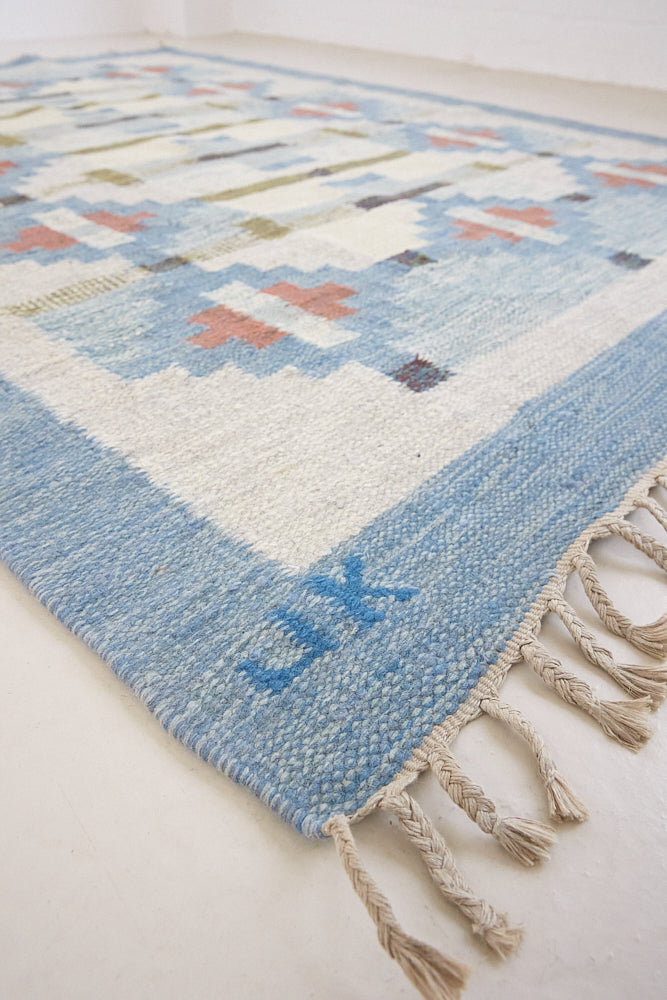 Erin is an original röllakan by the textile designer Karin Jonsson. This vintage rug features a beautiful and unique blue, pink and green colour palette and a geometric design.