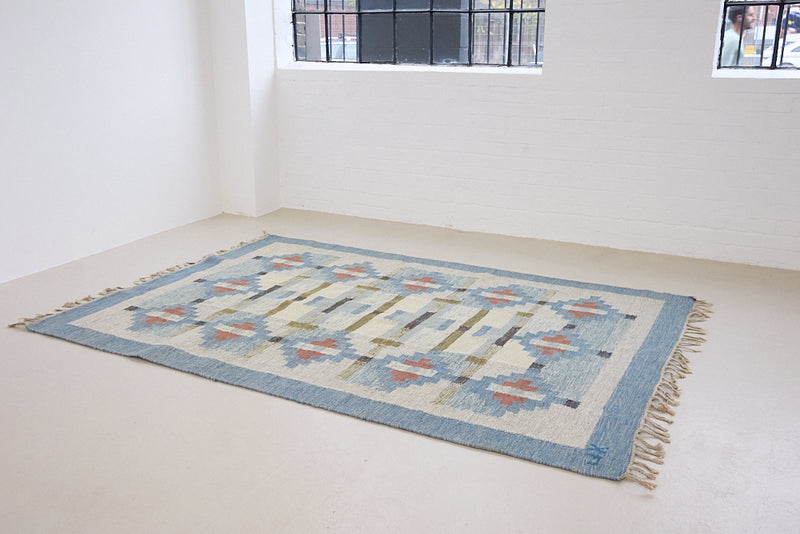 Erin is an original röllakan by the textile designer Karin Jonsson. This vintage rug features a beautiful and unique blue, pink and green colour palette and a geometric design.
