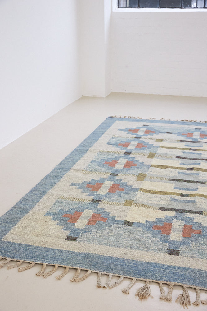 Erin is an original röllakan by the textile designer Karin Jonsson. This vintage rug features a beautiful and unique blue, pink and green colour palette and a geometric design.