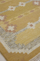 Luisa is a Swedish röllakan rug by textile designer Karin Jonsson. This unique rug features a beautiful ochre yellow colour palette and a geometric design