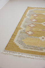 Luisa is a Swedish röllakan rug by textile designer Karin Jonsson. This unique rug features a beautiful ochre yellow colour palette and a geometric design
