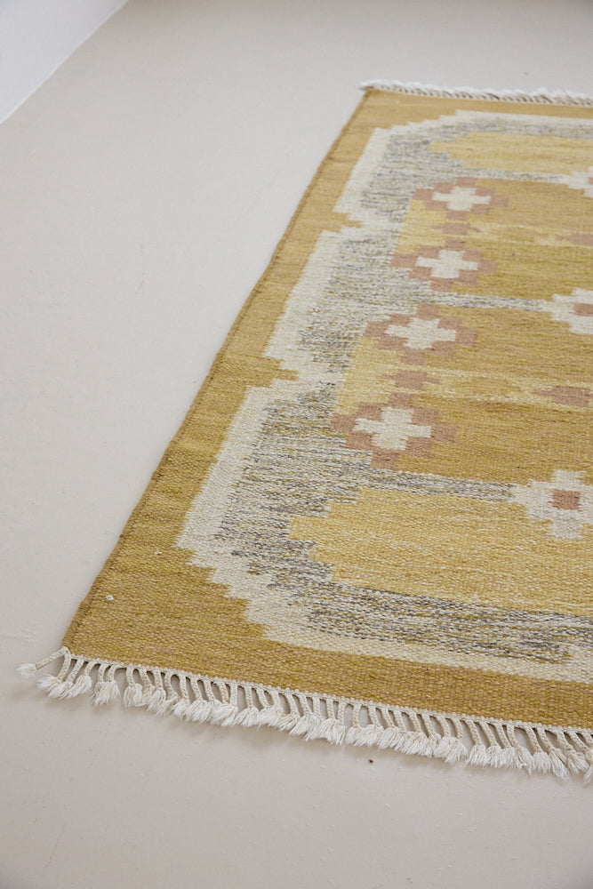 Luisa is a Swedish röllakan rug by textile designer Karin Jonsson. This unique rug features a beautiful ochre yellow colour palette and a geometric design