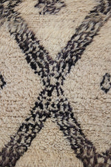 Remi is a vintage Beni Ourain from the middle Atlas mountains, with a rare design featuring tribal symbology. Thick natural wool carpet in black and white pattern.