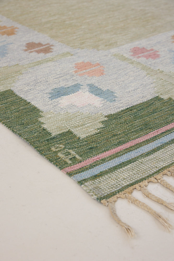 Trudie is an original Swedish röllakan rug handwoven by mid-century textile designer Anna Johanna Angström. Green colour-way featuring floral motifs 