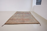 Sylvie is a peach and dark blue geometric patterned vintage Beni Ourain rug with a thick, cozy pile. 