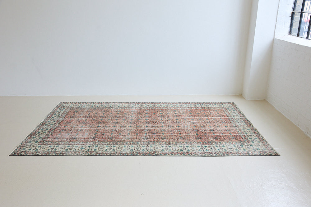 Dot is a vintage Turkish wool rug handwoven in Turkey approximately 80 years ago. The warm terracotta field and is decorated with an all floral scrolls pattern framed by a contrasting taupe boarder. 