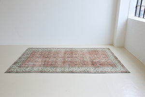 Dot is a vintage Turkish wool rug handwoven in Turkey approximately 80 years ago. The warm terracotta field and is decorated with an all floral scrolls pattern framed by a contrasting taupe boarder. 