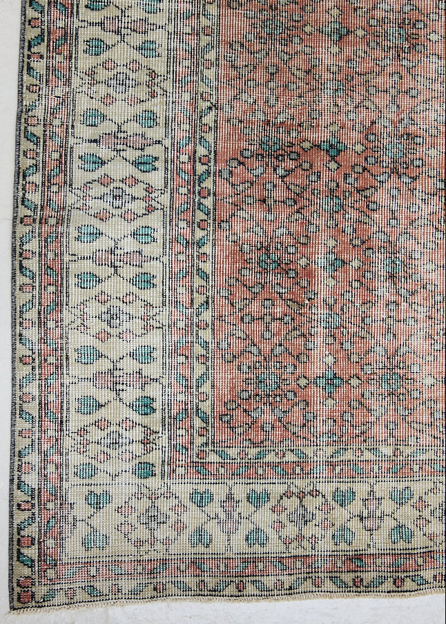 Dot is a vintage Turkish wool rug handwoven in Turkey approximately 80 years ago. The warm terracotta field and is decorated with an all floral scrolls pattern framed by a contrasting taupe border. 