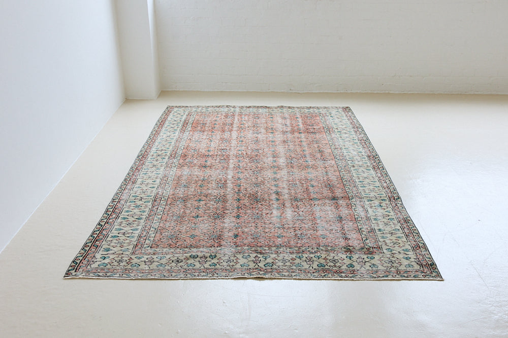 Dot is a vintage Turkish wool rug handwoven in Turkey approximately 80 years ago. The warm terracotta field and is decorated with an all floral scrolls pattern framed by a contrasting taupe boarder. 