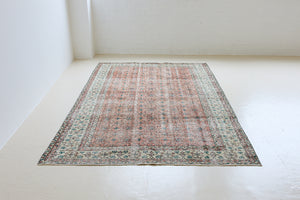Dot is a vintage Turkish wool rug handwoven in Turkey approximately 80 years ago. The warm terracotta field and is decorated with an all floral scrolls pattern framed by a contrasting taupe boarder. 