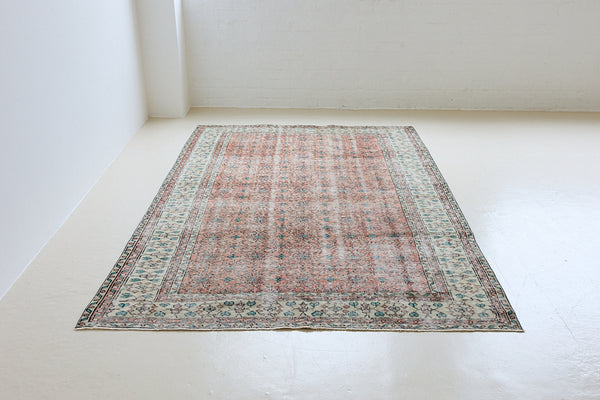 Dot is a vintage Turkish wool rug handwoven in Turkey approximately 80 years ago. The warm terracotta field and is decorated with an all floral scrolls pattern framed by a contrasting taupe boarder. 