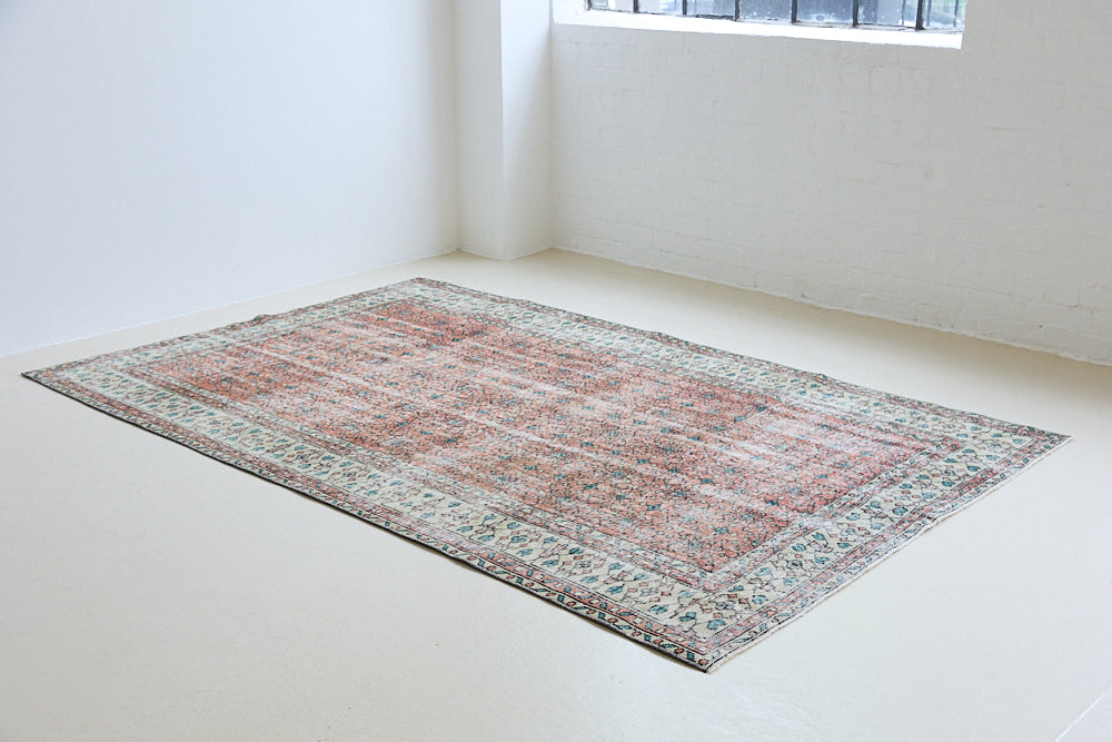 Dot is a vintage Turkish wool rug handwoven in Turkey approximately 80 years ago. The warm terracotta field and is decorated with an all floral scrolls pattern framed by a contrasting taupe boarder. 