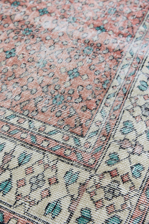 Dot is a vintage Turkish wool rug handwoven in Turkey approximately 80 years ago. The warm terracotta field and is decorated with an all floral scrolls pattern framed by a contrasting taupe boarder. 
