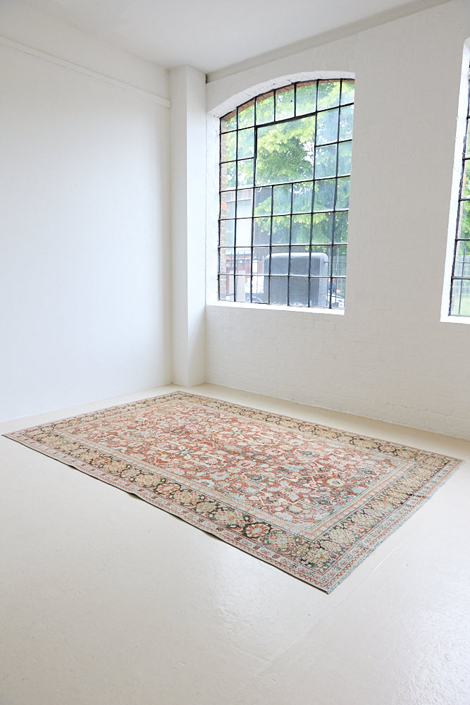 Mahals are known for decorative designs and repeating floral patterns. This antique rug features a beautiful earthy red ground complimented by a dark blue border.