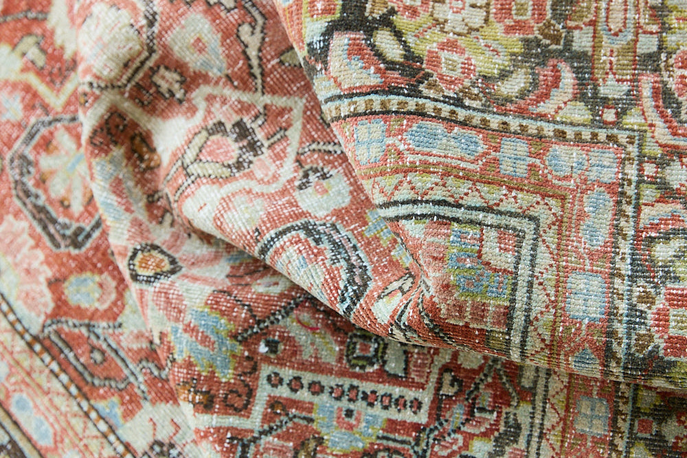 Mahals are known for decorative designs and repeating floral patterns. This antique rug features a beautiful earthy red ground complimented by a dark blue border.