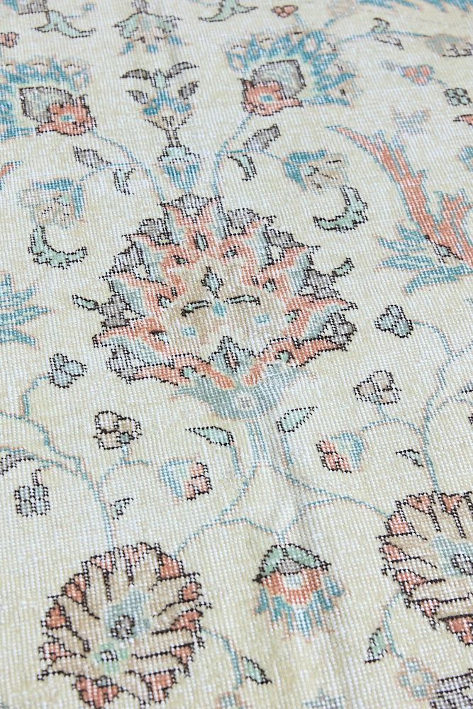 Genevieve is a vintage Turkish Oushak rug. Oushaks are defined by their softness in palette and large-scale, open compositions.The muted beige field is decorated with pretty floral scrolls, framed by a soft pinky red border.