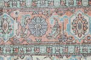 Genevieve is a vintage Turkish Oushak rug. Oushaks are defined by their softness in palette and large-scale, open compositions.The muted beige field is decorated with pretty floral scrolls, framed by a soft pinky red border.