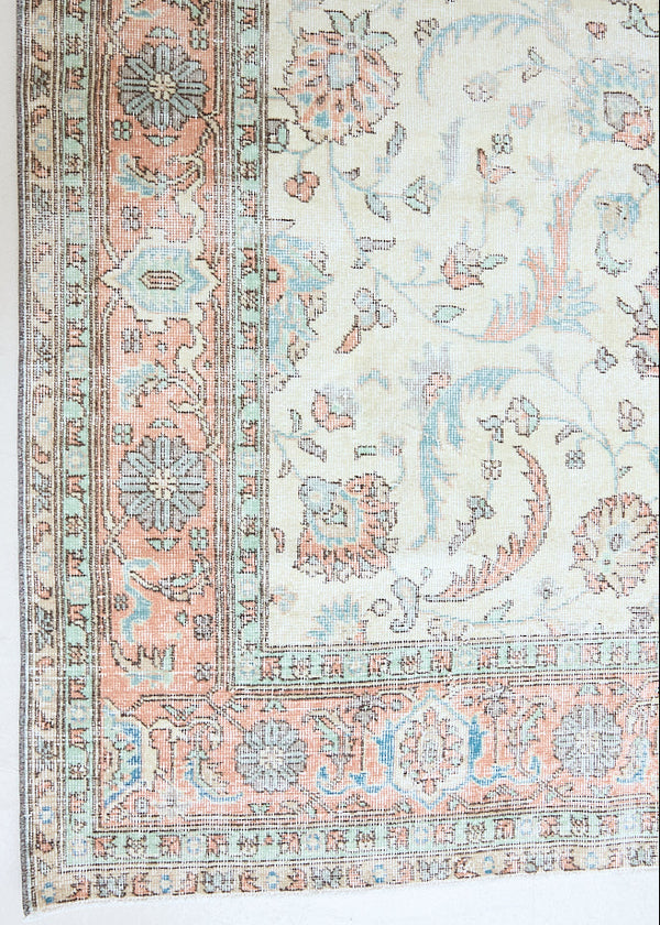 Genevieve is a vintage Turkish Oushak rug. Oushaks are defined by their softness in palette and large-scale, open compositions.The muted beige field is decorated with pretty floral scrolls, framed by a soft pinky red border.