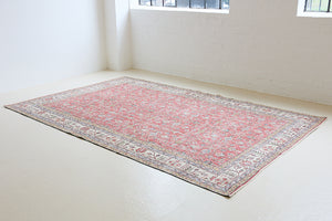 Ivy is a vintage rug handwoven in Turkey approximately 80 years ago. The warm red field and soft beige border are intertwined with an all over flowering vine pattern.