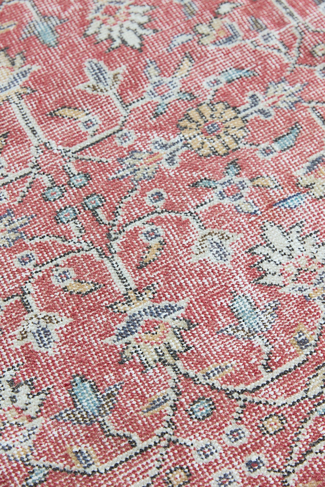 Ivy is a vintage rug handwoven in Turkey approximately 80 years ago. The warm red field and soft beige border are intertwined with an all over flowering vine pattern.