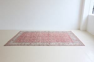 Ivy is a vintage rug handwoven in Turkey approximately 80 years ago. The warm red field and soft beige border are intertwined with an all over flowering vine pattern.