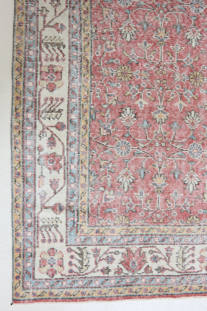 Ivy is a vintage rug handwoven in Turkey approximately 80 years ago. The warm red field and soft beige border are intertwined with an all over flowering vine pattern.