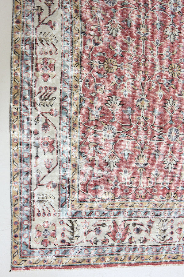 Ivy is a vintage rug handwoven in Turkey approximately 80 years ago. The warm red field and soft beige border are intertwined with an all over flowering vine pattern.