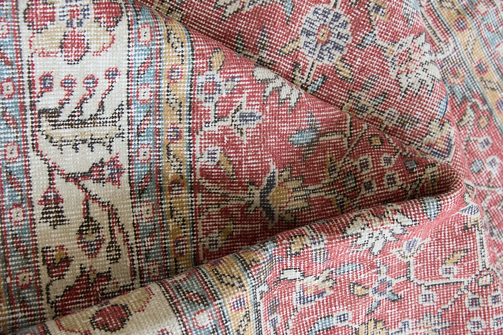 Ivy is a vintage rug handwoven in Turkey approximately 80 years ago. The warm red field and soft beige border are intertwined with an all over flowering vine pattern.