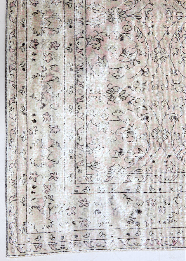 Josie is a vintage wool rug handwoven in Turkey approximately 80 years ago. The soft pink field of the Turkish carpet  is decorated with an all floral scrolls pattern framed by a subtle contrasting taupe boarder.