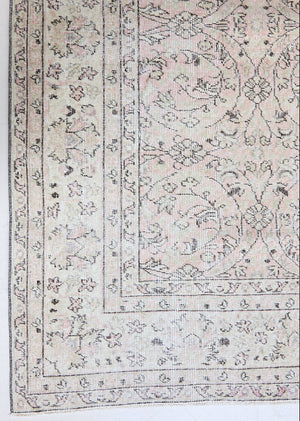 Josie is a vintage wool rug handwoven in Turkey approximately 80 years ago. The soft pink field of the Turkish carpet  is decorated with an all floral scrolls pattern framed by a subtle contrasting taupe boarder.