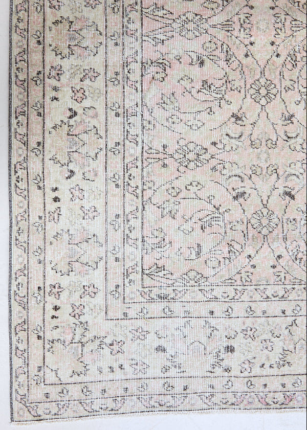 Josie is a vintage wool rug handwoven in Turkey approximately 80 years ago. The soft pink field of the Turkish carpet  is decorated with an all floral scrolls pattern framed by a subtle contrasting taupe boarder.
