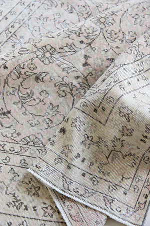 Josie is a vintage wool rug handwoven in Turkey approximately 80 years ago. The soft pink field and is decorated with an all floral scrolls pattern framed by a subtle contrasting taupe boarder.