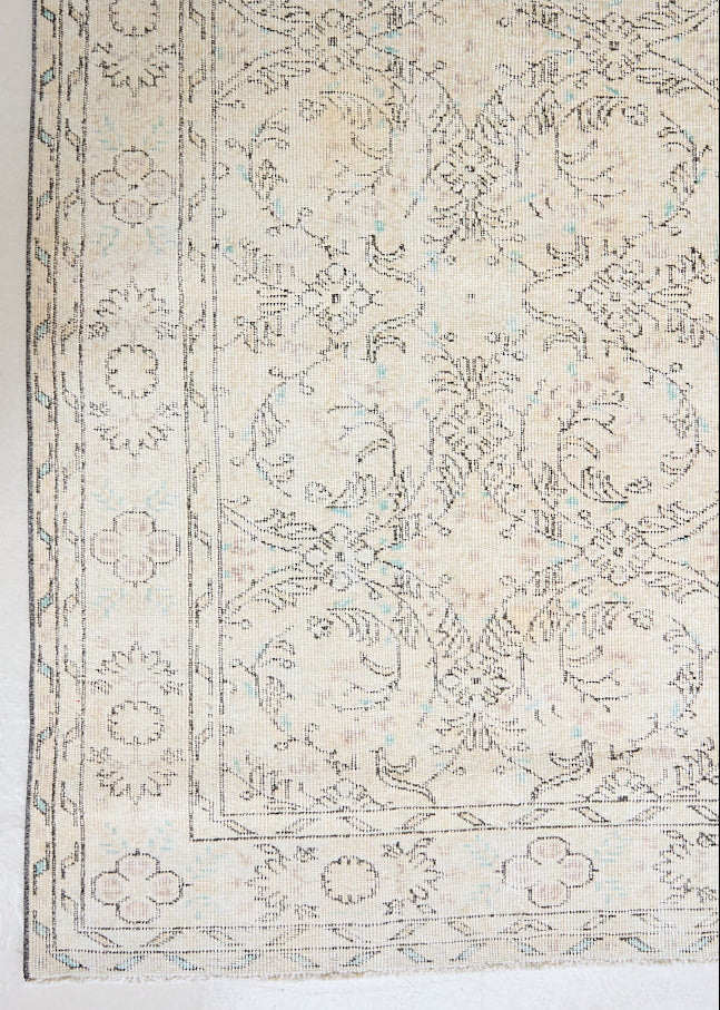 Lily is a vintage wool rug handwoven in Turkey approximately 80 years ago. The soft taupe field of this Turkish carpet is decorated with an all floral scrolls pattern framed by a subtle border.