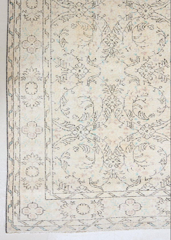 Lily is a vintage wool rug handwoven in Turkey approximately 80 years ago. The soft taupe field of this Turkish carpet is decorated with an all floral scrolls pattern framed by a subtle border.
