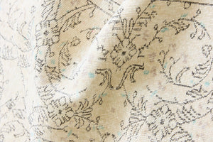 Lily is a vintage wool rug handwoven in Turkey approximately 80 years ago. The soft taupe field and is decorated with an all floral scrolls pattern framed by a subtle boarder.