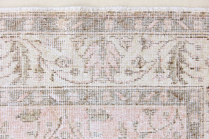 Lizzie is a vintage wool rug handwoven in Turkey approximately 70 years ago. The soft pink field and is decorated with an all floral scrolls pattern framed by a subtle contrasting taupe boarder.