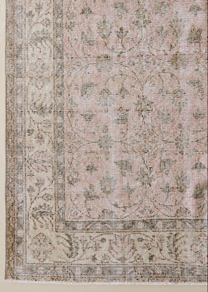 Lizzie is a vintage wool rug handwoven in Turkey approximately 70 years ago. The soft pink field of this Turkish carpet is decorated with an all floral scrolls pattern framed by a subtle contrasting taupe boarder.