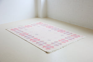Ola is an original 1960s röllakan flatweave rug, featuring a pretty geometric floral pattern. The rug is signed ILS.